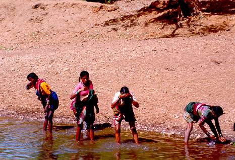 Tribal women washing at river bank in the state of Karnataka, Southern India.